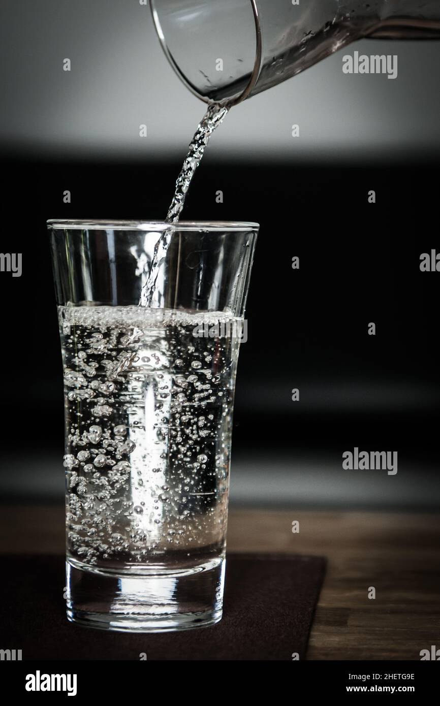 versando dell'acqua pulita fresca nel bicchiere con la caraffa Foto Stock versando dell'acqua pulita fresca nel bicchiere con la caraffa Foto Stock