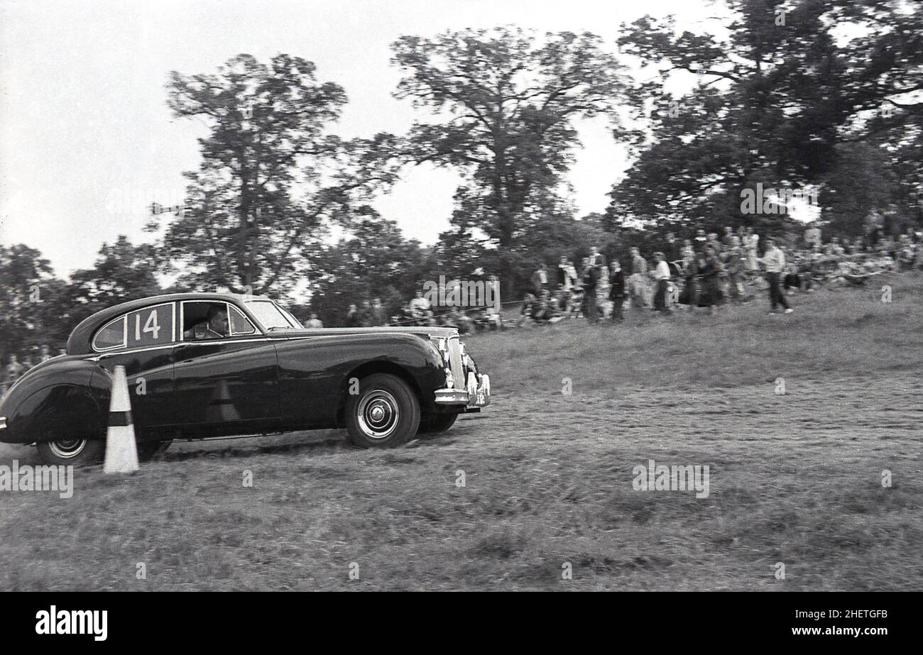 1950s, storico, motorsport, arrampicata o gara di erba pista, un conducente e grande berlina auto da corsa in un campo, l'auto è forse un Bentley, Inghilterra, Regno Unito. Foto Stock