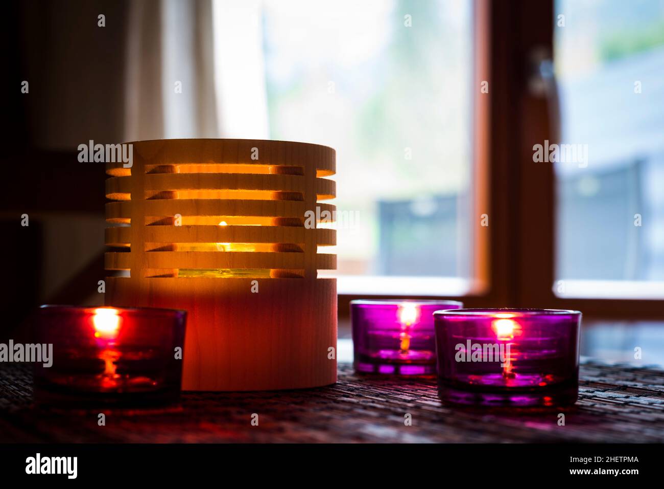 candele da tè in legno e vetro in piedi su un tappeto di canna Foto Stock