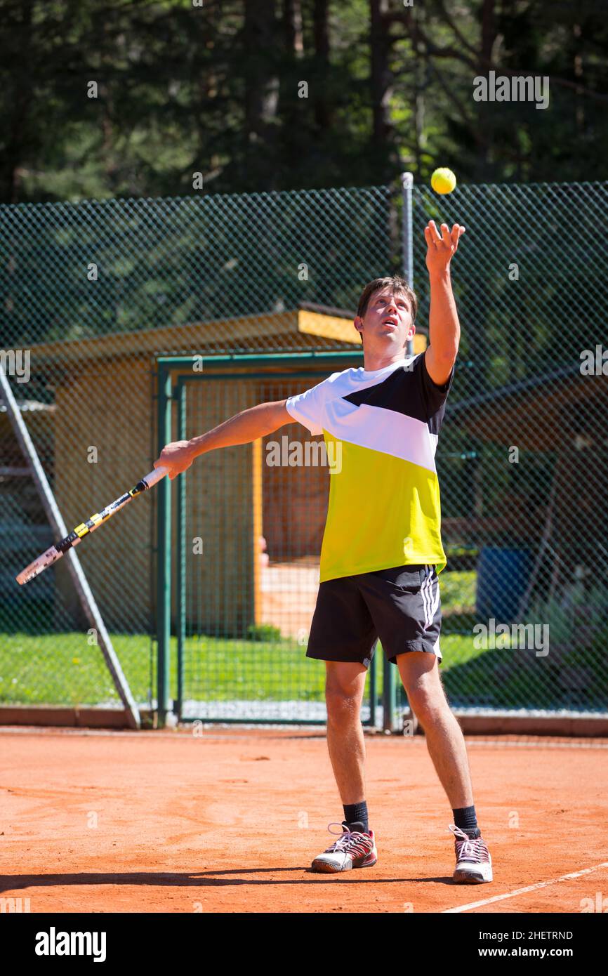 il giocatore di tennis lancia la palla per servire Foto Stock