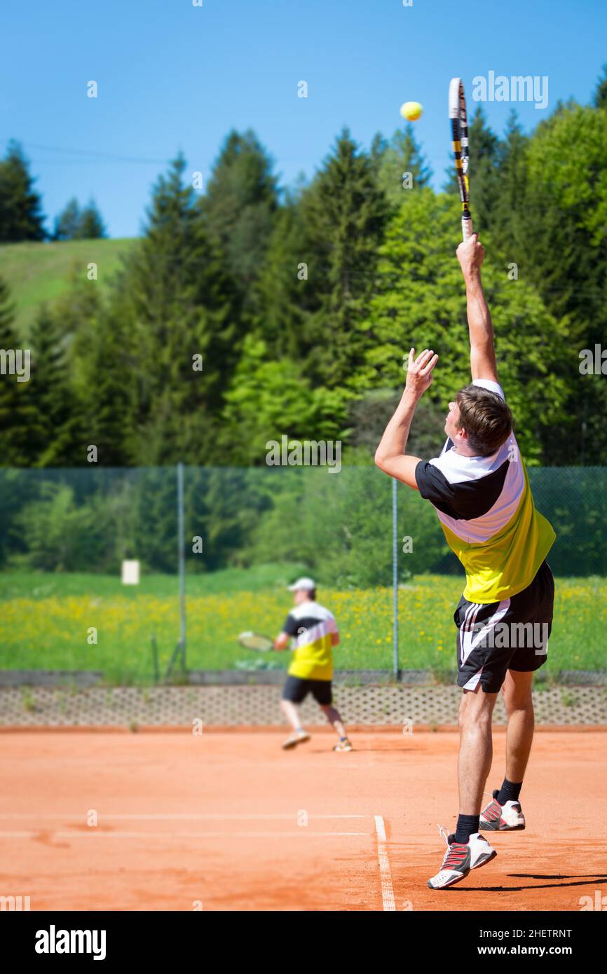 i giocatori di tennis sul campo di sabbia uno sta servendo Foto Stock
