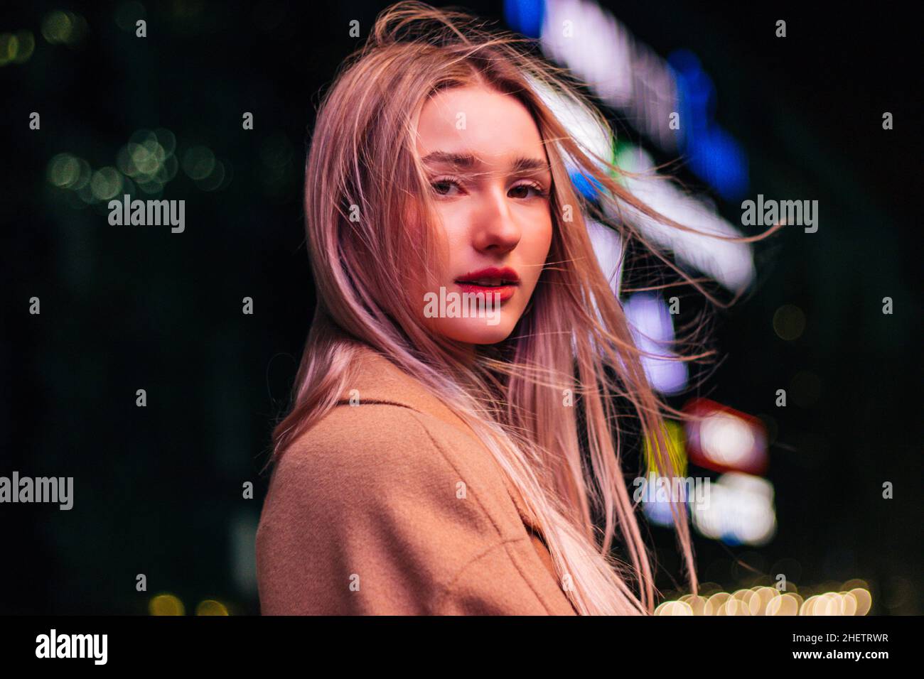 bella giovane ragazza bionda passeggiate per la città notturna Foto Stock