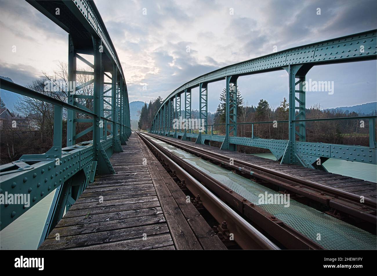 ponte ferroviario con struttura in acciaio dipinto di ciano sul fiume Foto Stock