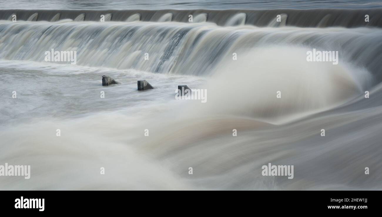 scalino acqua fluviale con acqua corrente e spume con elementi in calcestruzzo Foto Stock