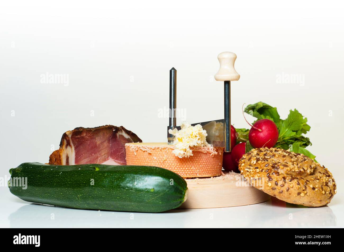 un pasto o uno spuntino composto da pane, formaggio, pancetta, squash verde e ravanello Foto Stock