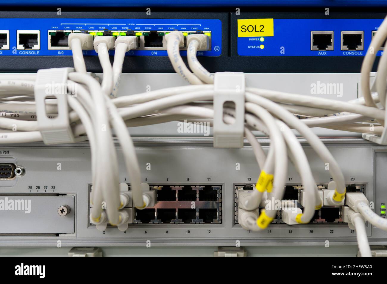 Ambiente IT con switch e firewall collegati con cavi Ethernet patch grigi Foto Stock