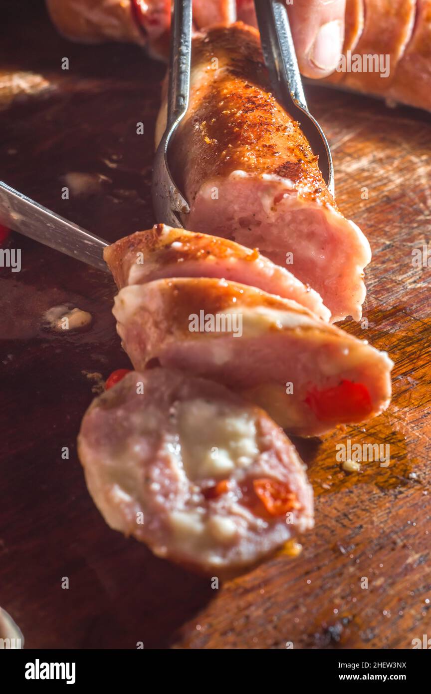 Salsiccia e peperoni, salsiccia artigianale con formaggio e pepe su un asse di legno, spazio copia e fuoco selettivo Foto Stock