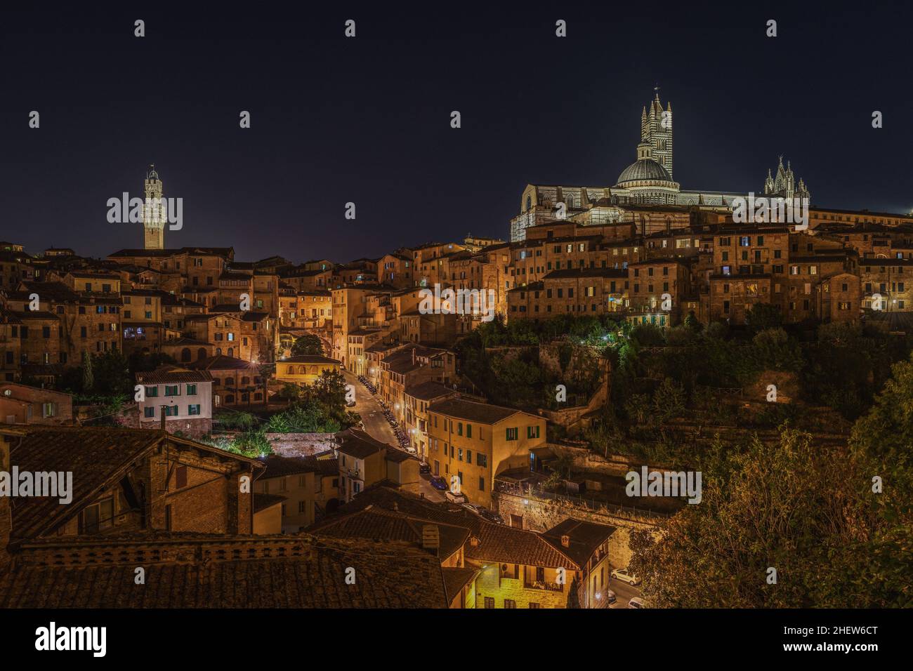 Incredibile paesaggio urbano notturno con due punti di riferimento iconici: Torre del Mangia sulla destra e la Cattedrale di Siena sulla sinistra, Toscana, Italia Foto Stock