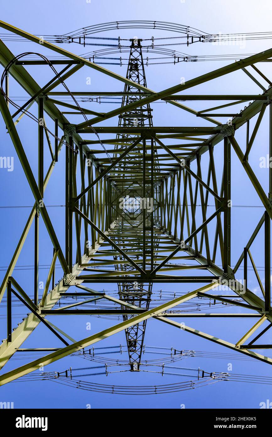 pilone elettrico sotto il cielo blu come sfondo industriale Foto Stock