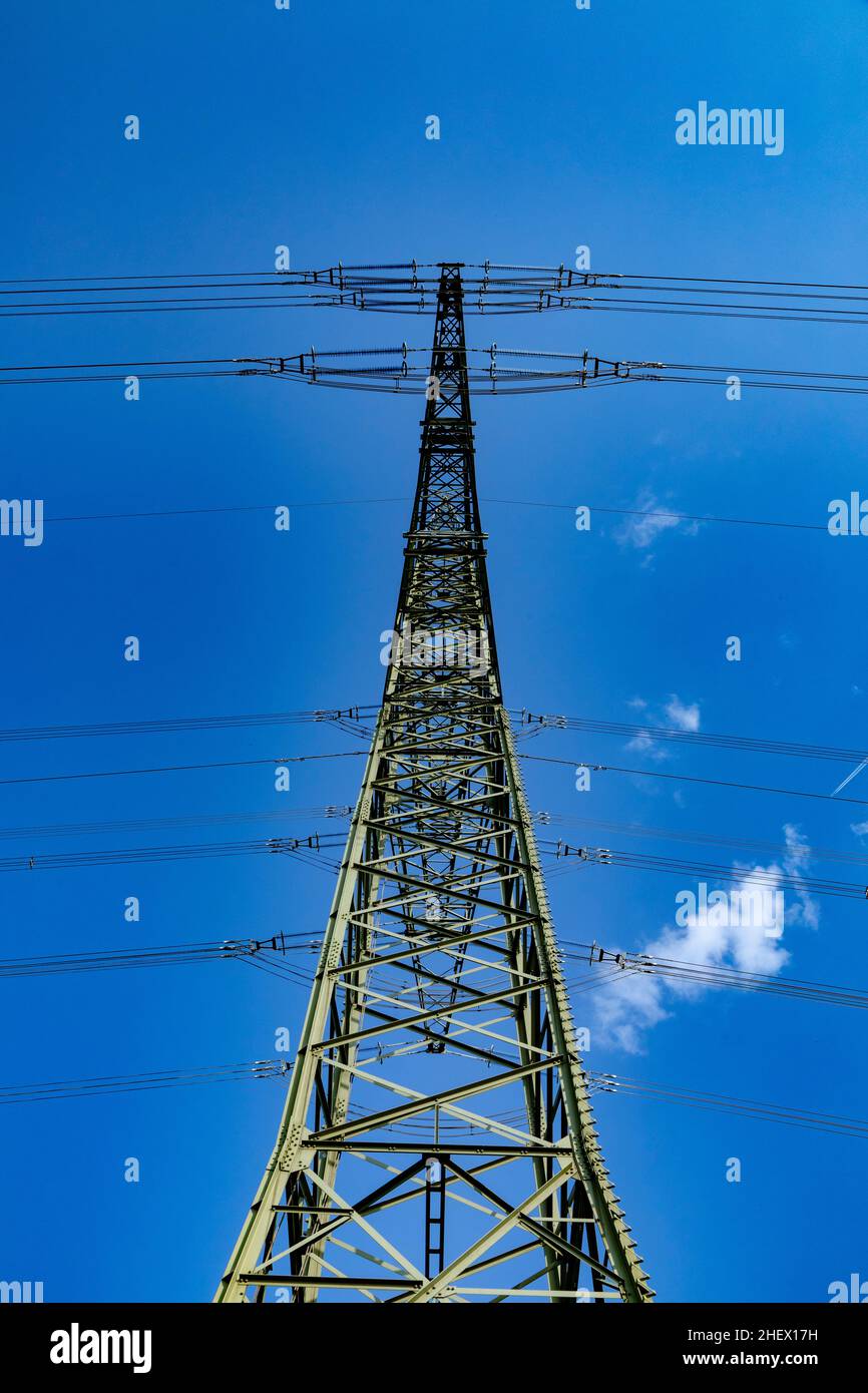 pilone elettrico sotto il cielo blu come sfondo industriale Foto Stock