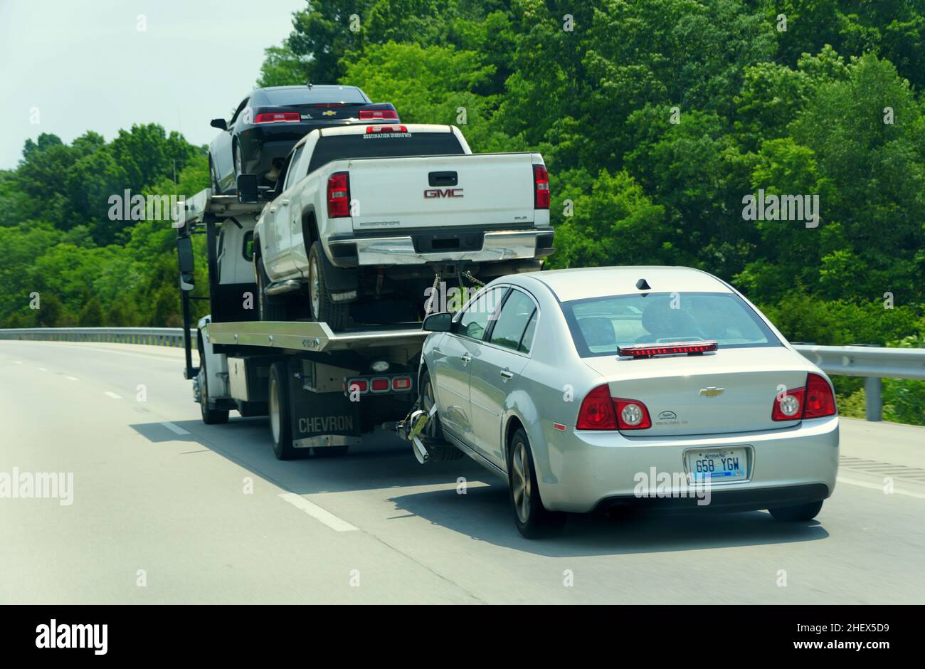 Kentucky, U.S.A - 20 agosto 2021 - due automobili ed un camion di pick-up sono trainati da un camion grande Foto Stock