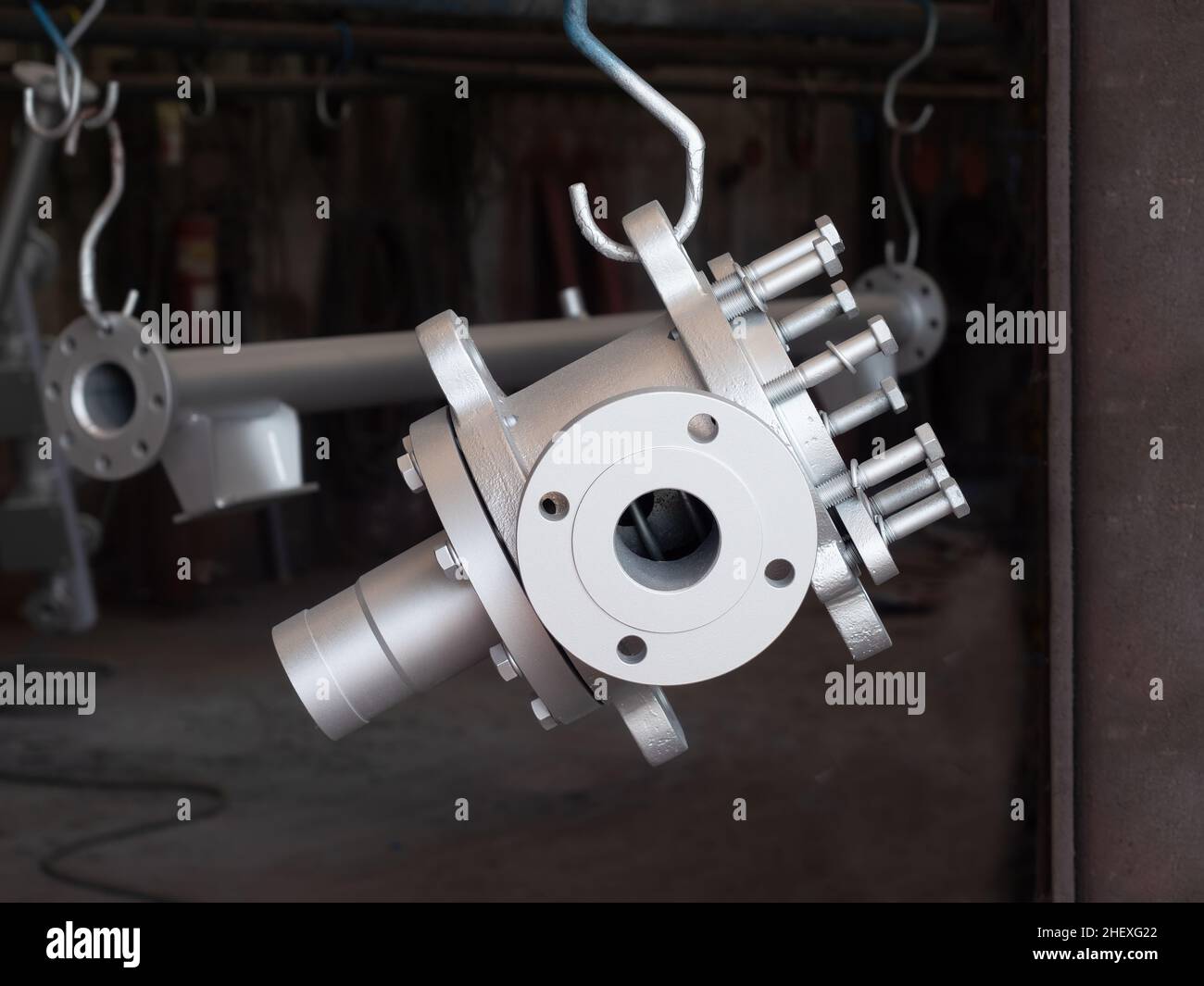 Componente in acciaio verniciato con vernice argentata presso un'officina di verniciatura industriale Foto Stock