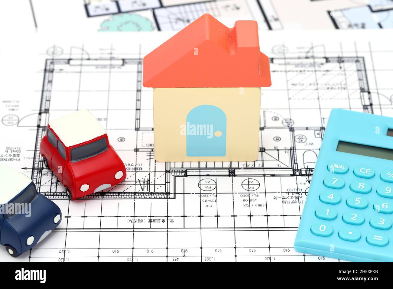 KAGAWA, GIAPPONE - 11 GENNAIO 2022: Piccola auto giocattolo e casa giocattolo in legno primo piano immagine su sfondo blueprint. Foto Stock