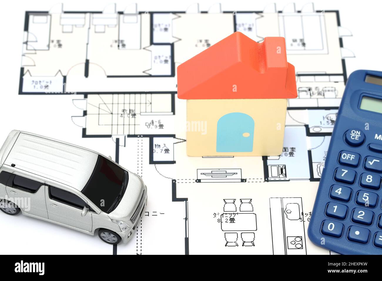 KAGAWA, GIAPPONE - 11 GENNAIO 2022: Piccola auto giocattolo e casa giocattolo in legno primo piano immagine su sfondo blueprint. Foto Stock