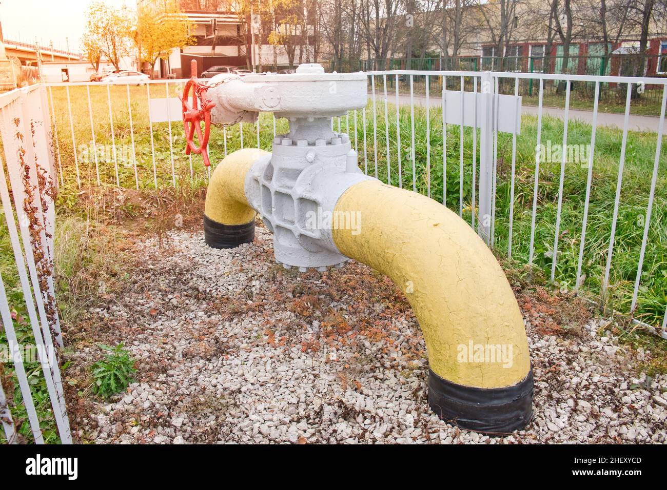 Frammento della tubazione del gas con valvola a sfera flangiata circondata dalla recinzione metallica. Sistema di alimentazione del gas urbano. Foto Stock