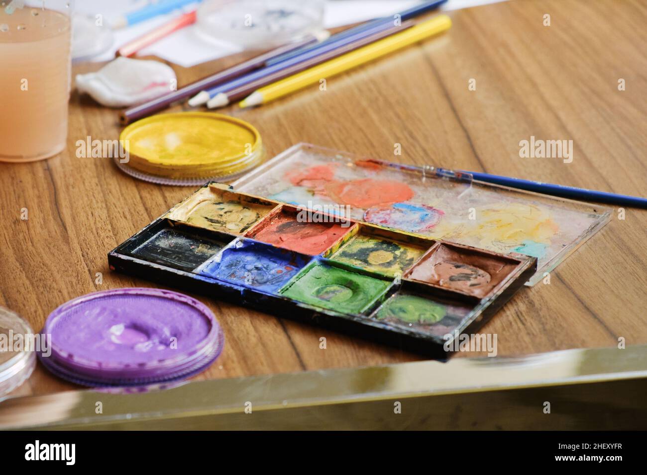 Strumenti artistici per disegnare dipinti su tavola in legno. Tavolozza, acquerello, pennelli, matite colorate. Foto Stock