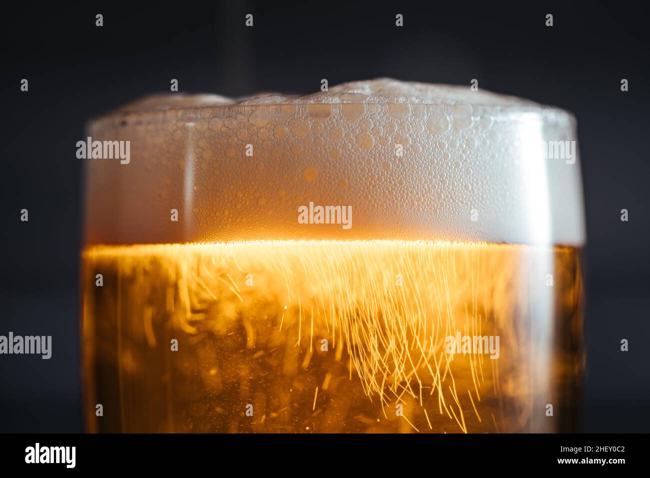 Bicchiere di birra con schiuma e quattro diversi snack Foto Stock