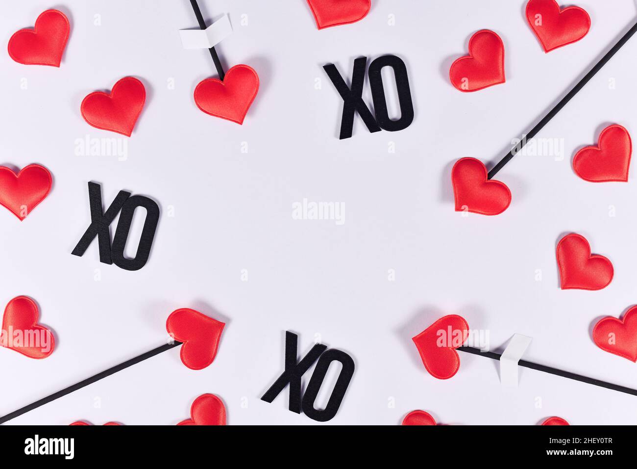 Il giorno di Valentne è al confine con le frecce d'amore di Cupid e il testo XO su sfondo bianco con spazio di copia Foto Stock
