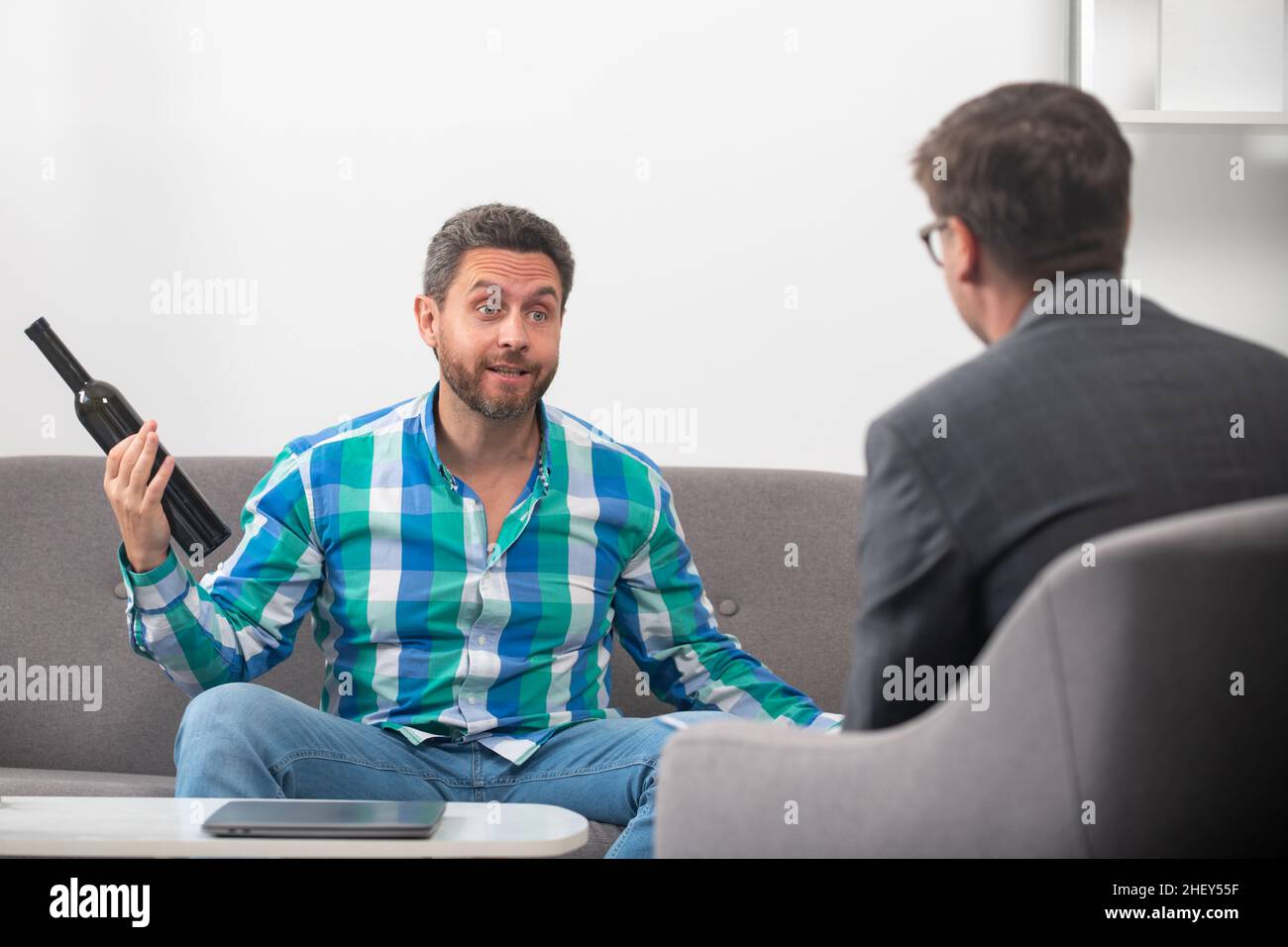 Risolvere il problema, dipendenza da alcol, arrabbiato eccitato uomo abuso di alcol. Psicologia, concetto di terapia mentale. Alcolismo, alcolico e psicologo a Foto Stock