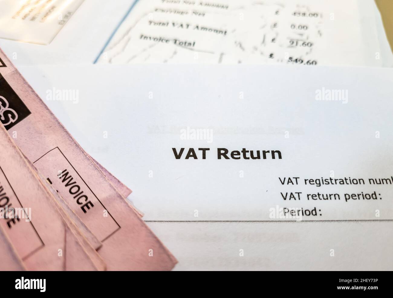 Primo piano di un documento di imposta sul valore aggiunto britannico con fatture su una scrivania. Foto Stock