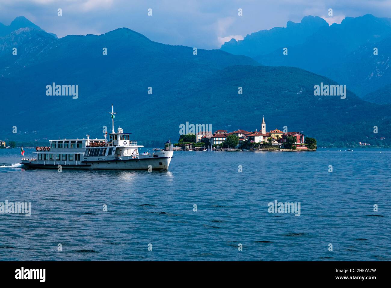 Vista sull'isola Isola superiore, la torre della chiesa di San Vittore che si erge, sul Lago maggiore, circondando montagne in lontananza, a Foto Stock