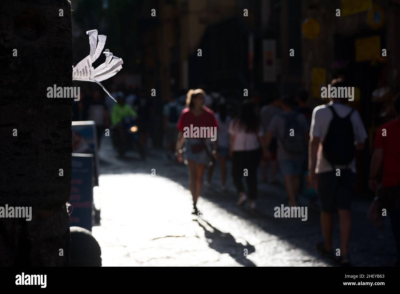 Pubblicità fatta a mano sul muro contro le persone sfocate che camminano lungo la strada Foto Stock