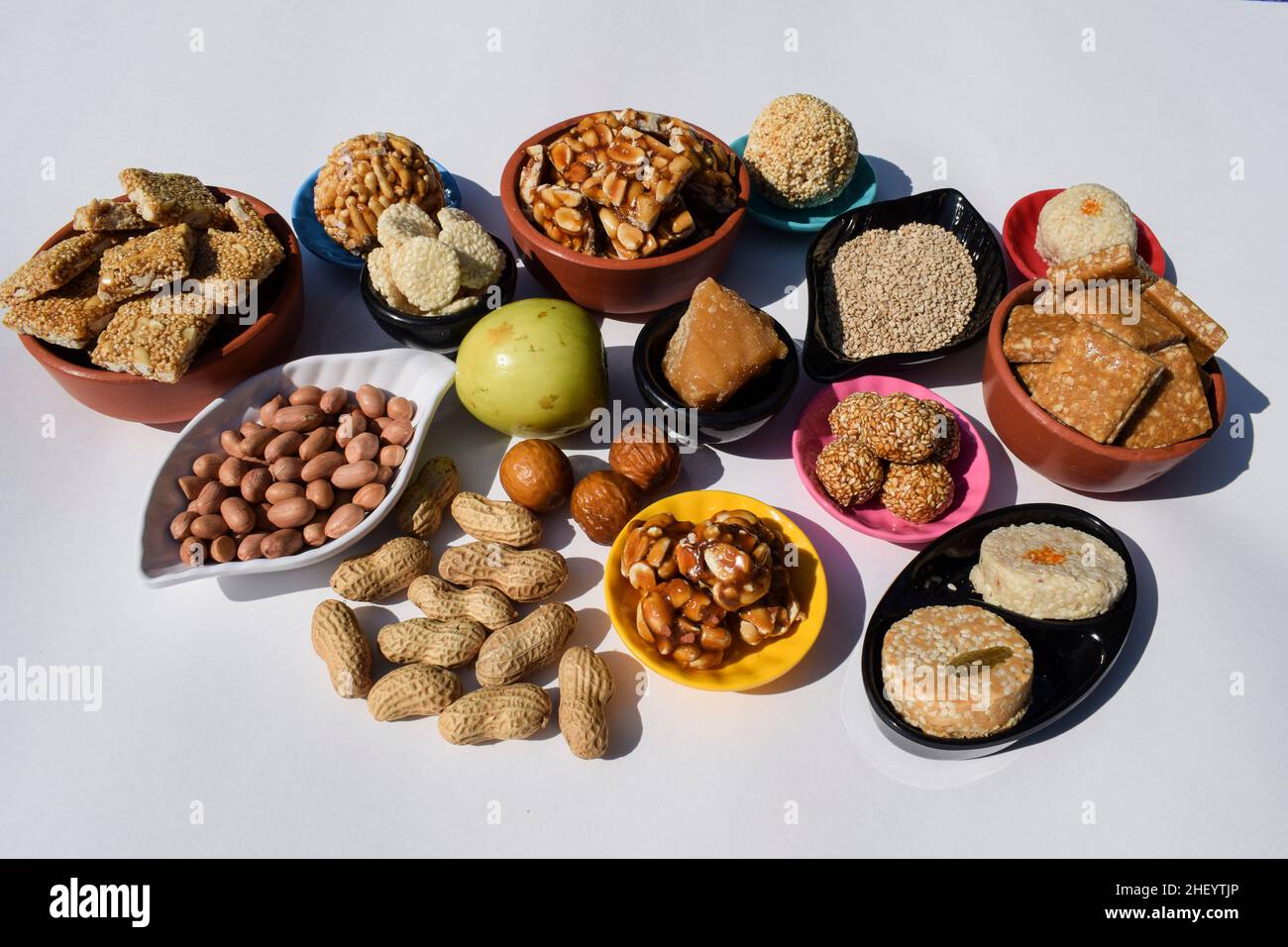 Makar sankranti festival tradizioni di servire e mangiare Peanut chikki, semi di sesamo laddu, til ladoo, indiano verde mela berro, bora, arachidi. E Foto Stock