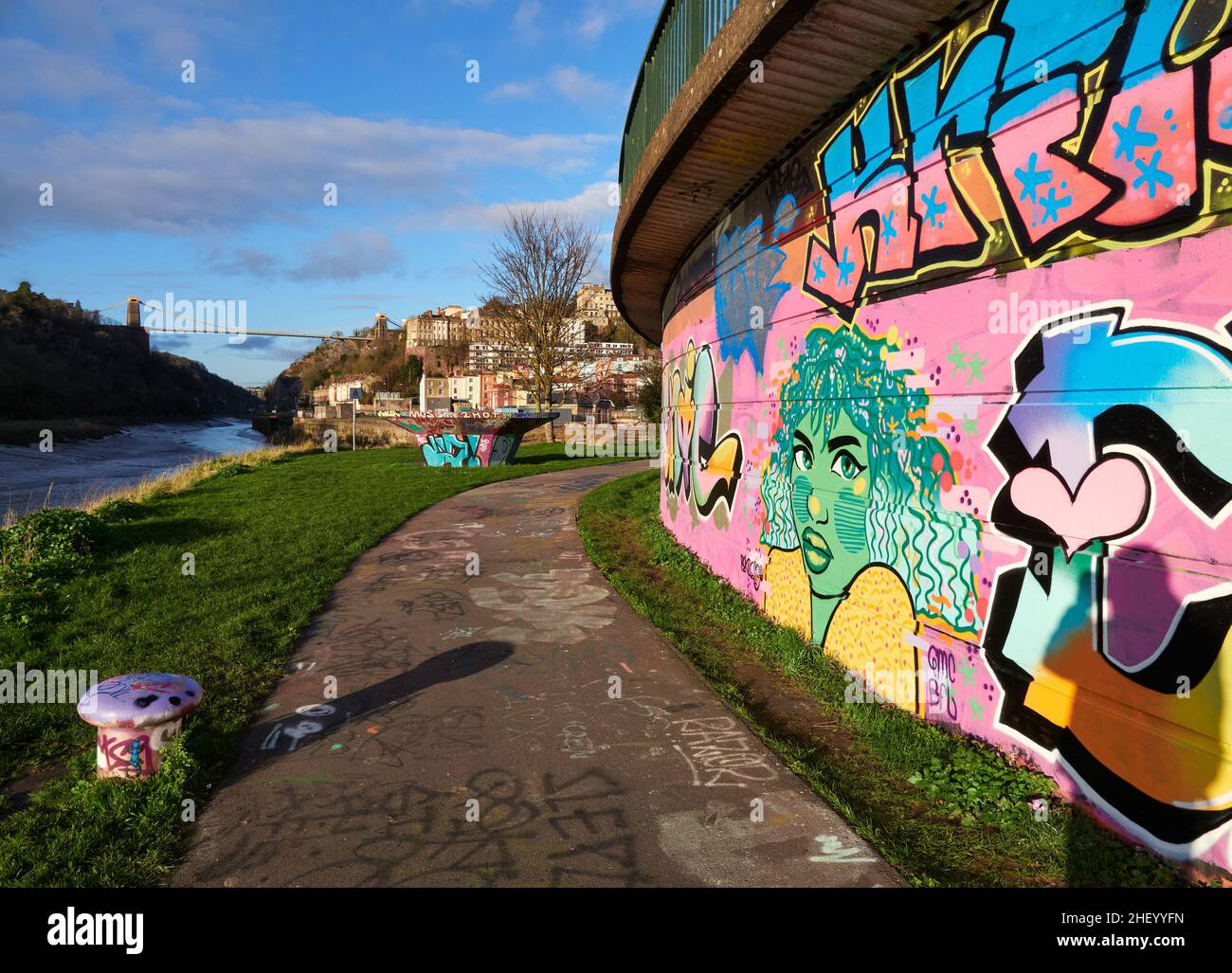 Graffiti Street art sul sistema stradale Cumberland Basin presso il River Avon e Clifton Suspension Bridge a Bristol UK - con ombra di una figura Foto Stock