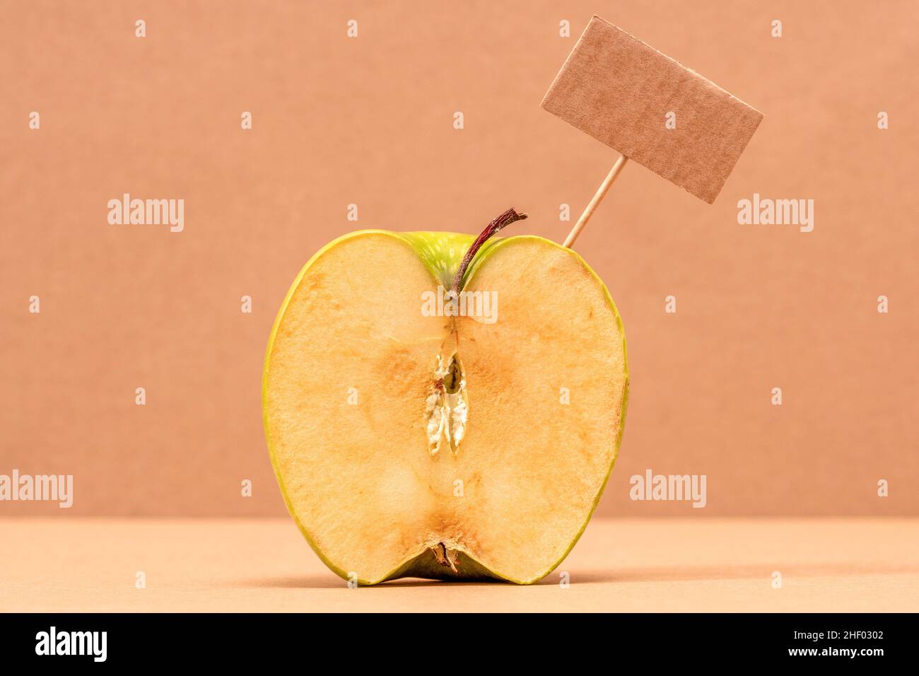 Apple verde con etichetta prezzo vuota o pannello di carta vuoto. Spazio di copia. Foto Stock