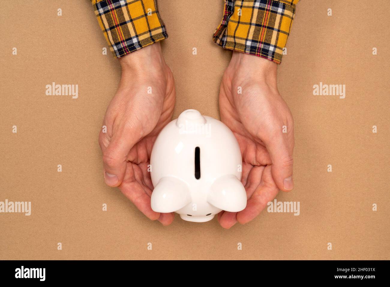 Piggy banca protetto dalle mani. Protegga il vostro money.Saving, investimento di affari, concetto di pensione. Foto Stock
