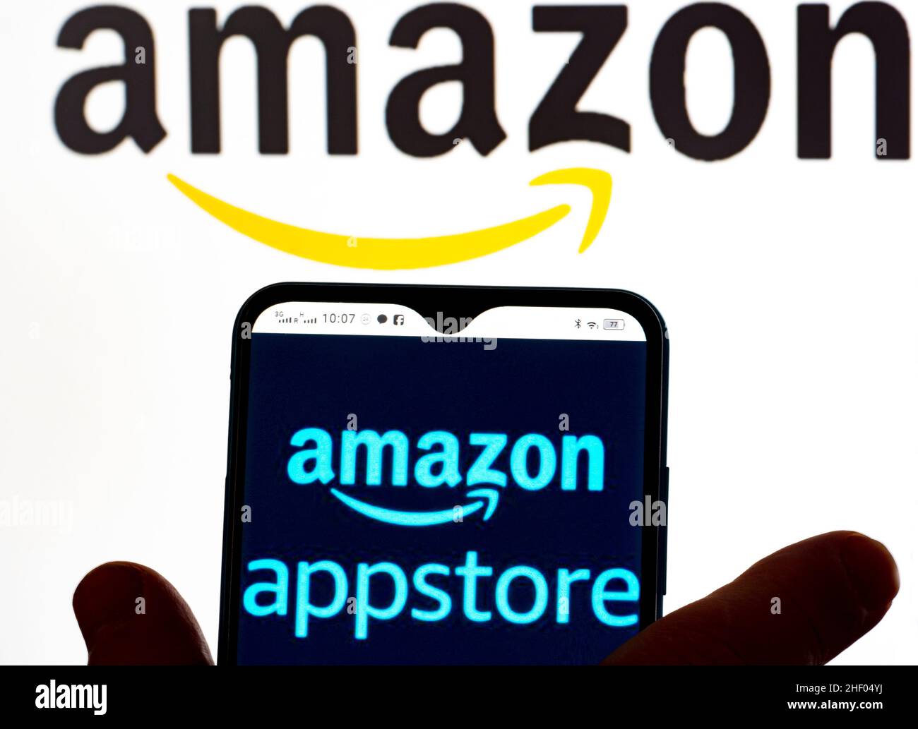 In questa illustrazione della foto, il logo Amazon AppStore viene visualizzato sullo schermo di uno smartphone e il logo Amazon sullo sfondo. Foto Stock