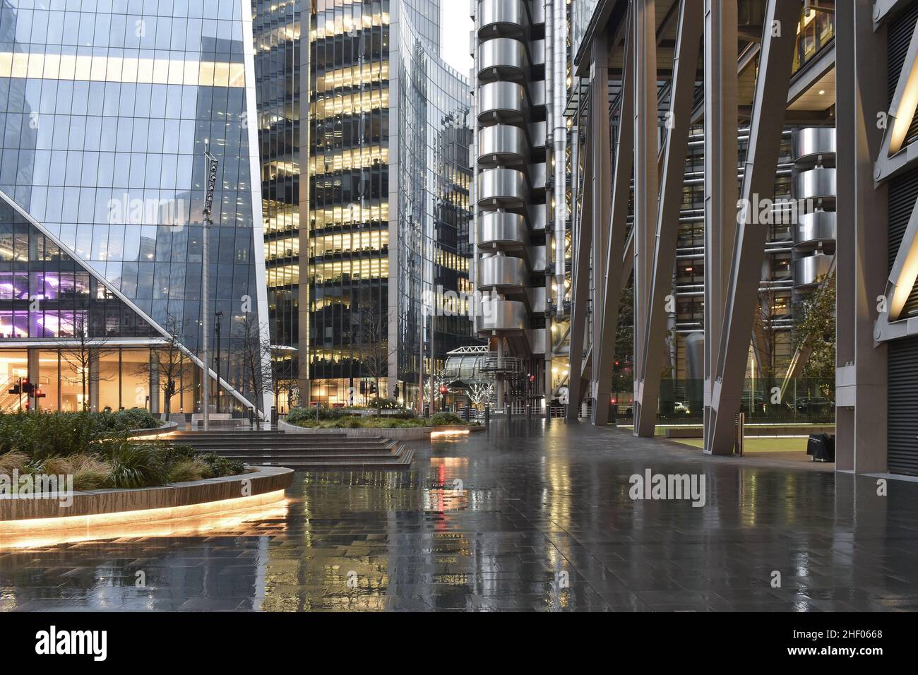 Edifici moderni per uffici e passerella pavimentata, serata piovosa nella City of London UK. Foto Stock