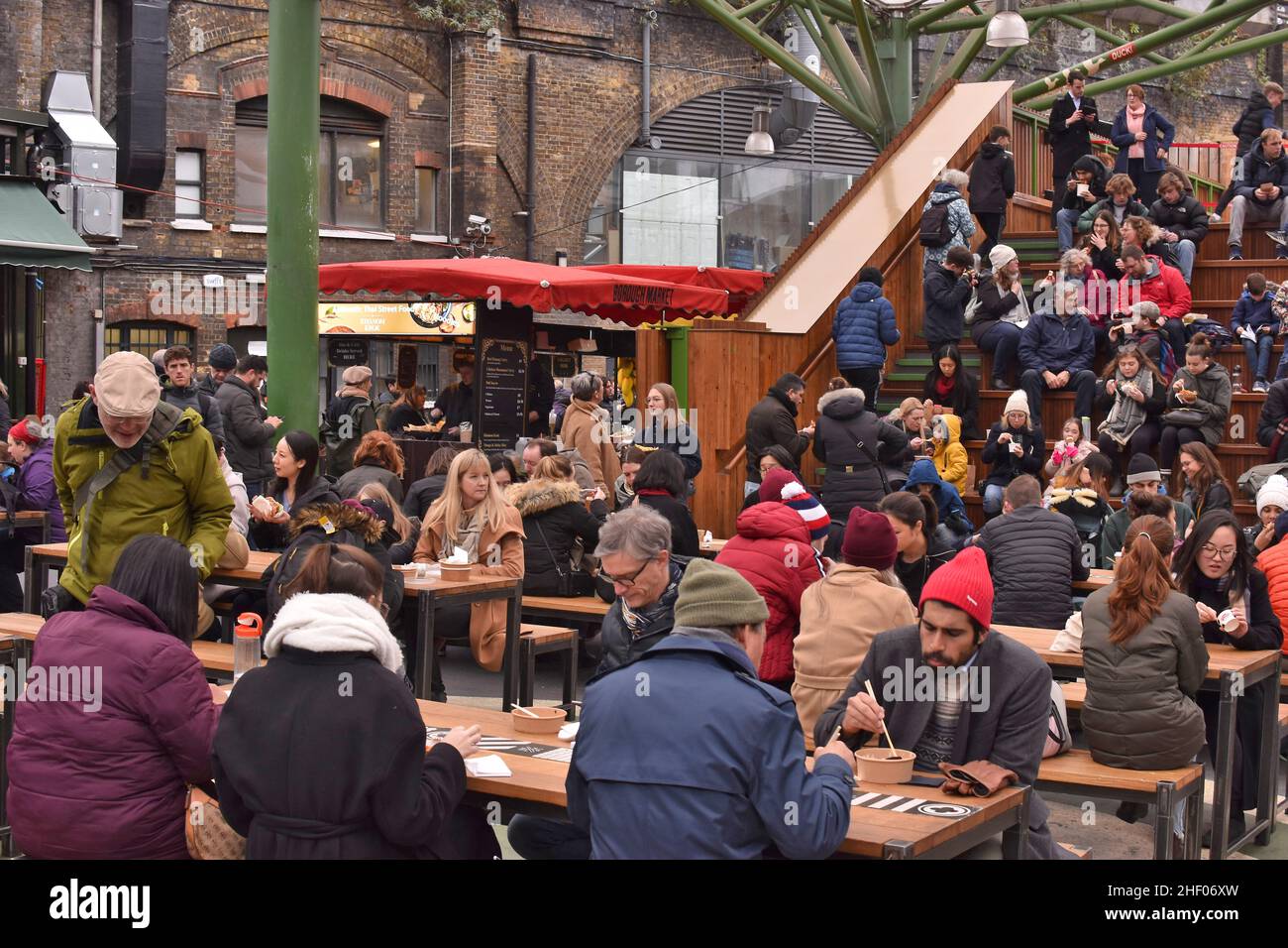 La gente che siede e cena al Borough Market open-air food Court, Southwark London UK. Foto Stock