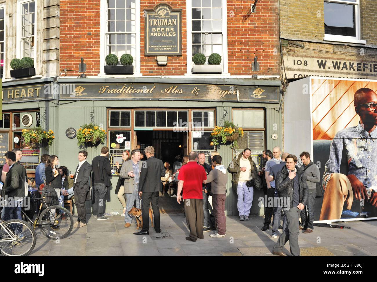 Persone al di fuori del Golden Heart Pub a Shoreditch East London UK. Foto Stock