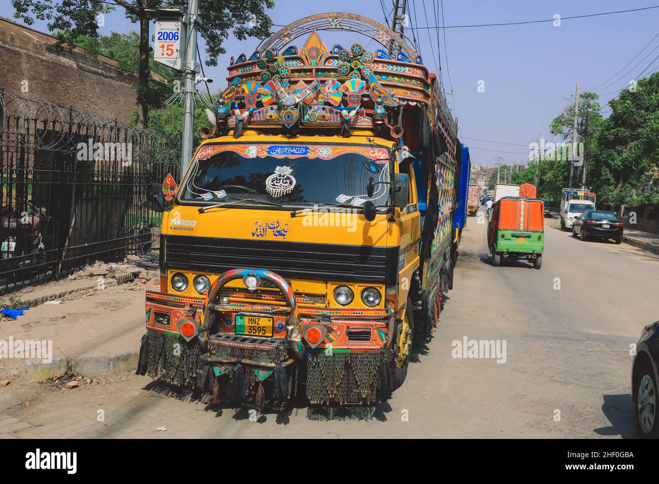 Lahore, Pakistan - 1 luglio 2020: Luminoso e colorato camion pakistano giallo con decorazioni e design tradizionali sulla via Lahore Foto Stock