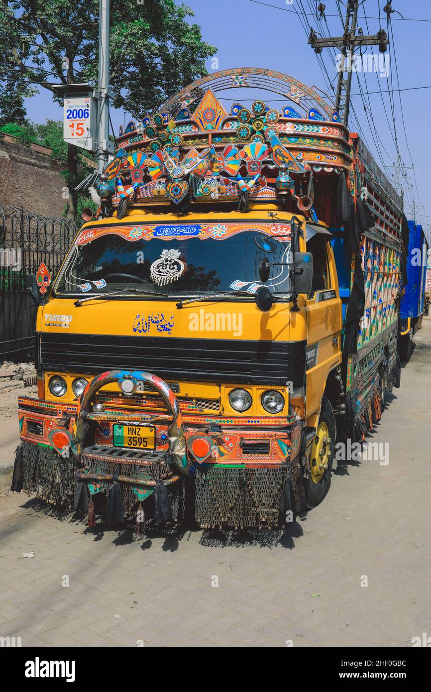 Lahore, Pakistan - 1 luglio 2020: Luminoso e colorato camion pakistano giallo con decorazioni e design tradizionali sulla via Lahore Foto Stock