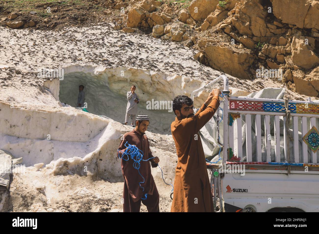 Gilgit, Pakistan - 08 giugno 2018: Le persone pakistane raccolgono neve e caricano l'auto in montagna Foto Stock