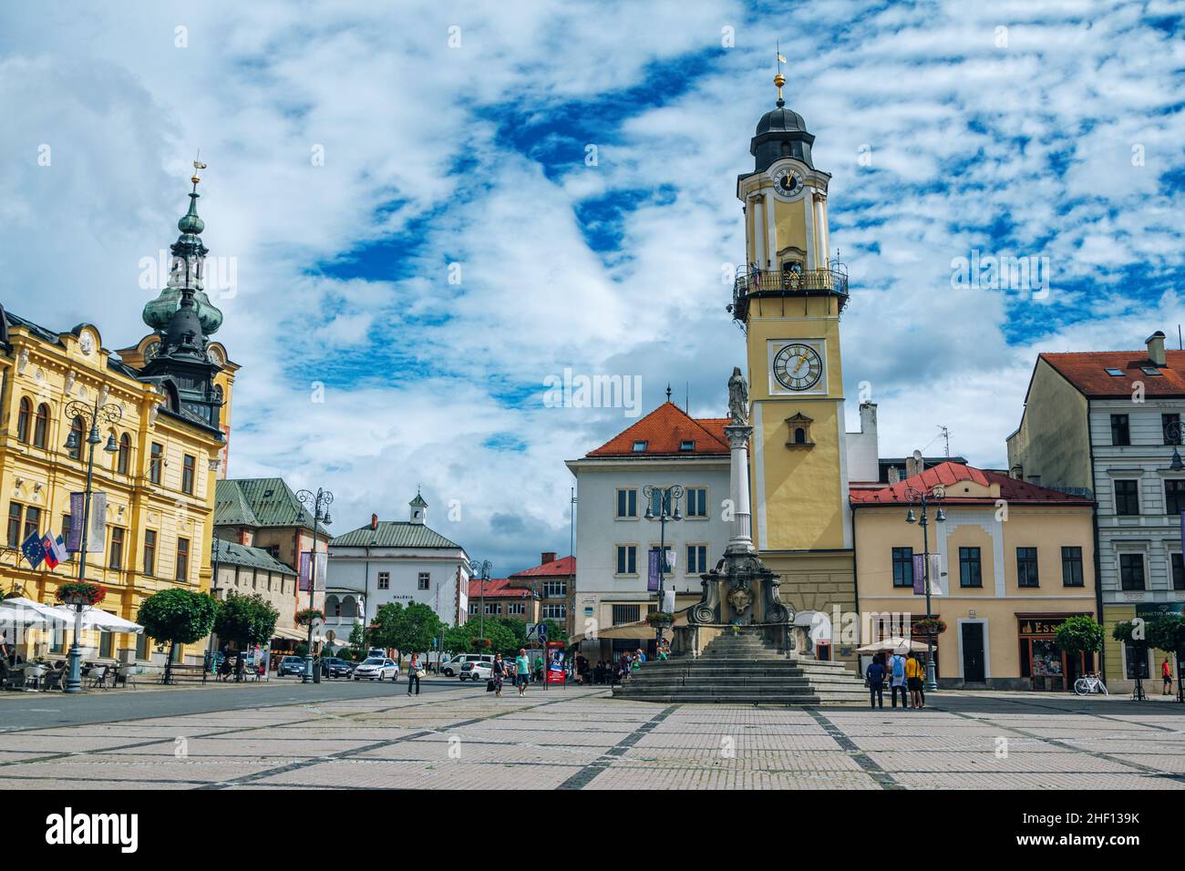 Banska Bystrica, Slovacchia – 15 agosto 2021: Vista di Piazza SNP – colorati edifici storici, torre dell'orologio e gente che cammina intorno. Foto Stock