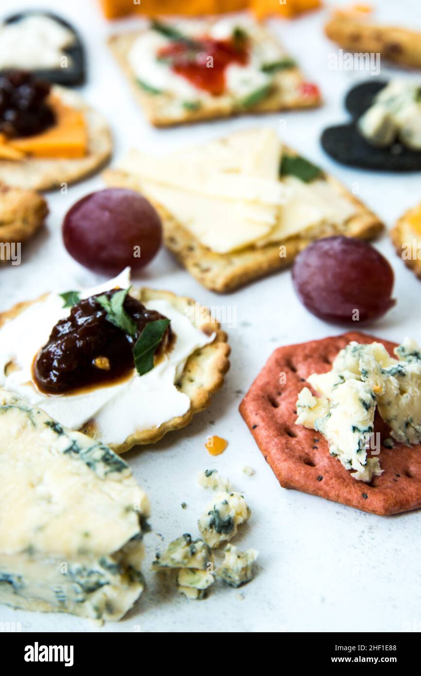 Fondo piatto di una selezione di formaggi e cracker come aperitivo o spuntino con guarnitura Foto Stock