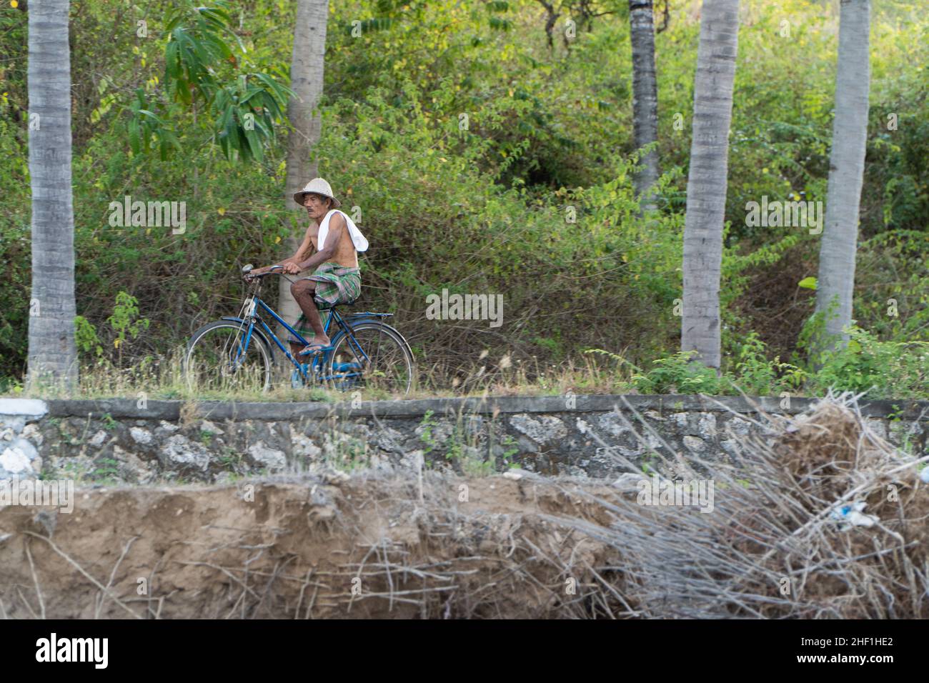 Nusa Penida, Bali-settembre 04 2021: Un agricoltore di alghe marine a Nusa Penida Bali sta raccogliendo le sue gabbie di alghe in un pomeriggio nuvoloso. L'erba è diventata la principale comun Foto Stock