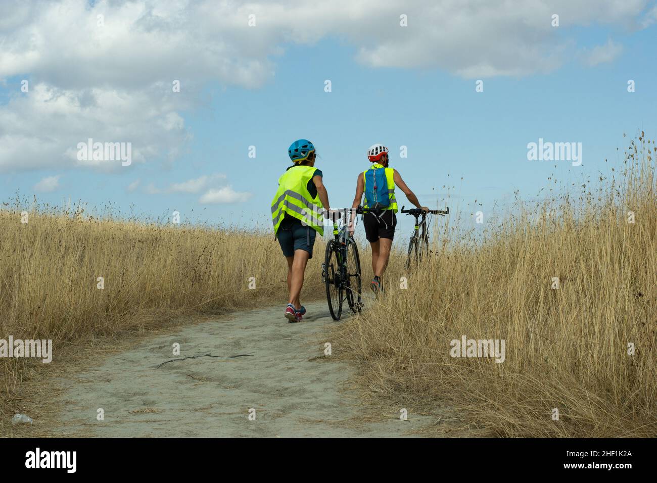 Pienza, Siena-Italia-Agosto 27,2021 ciclisti che camminano con le biciclette a mano sul sentiero Foto Stock