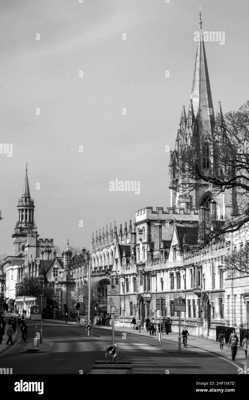 Edifici in pietra ornata in bianco e nero, con torri e guglie, che costeggiano una strada a Oxford, Inghilterra Foto Stock
