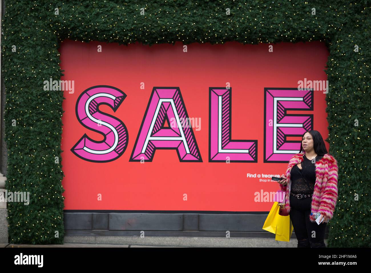 La gente con i sacchetti di shopping cammina il giorno di Santo Stefano nel centro di Londra mentre gli acquirenti si riuniscono su Oxford Street nonostante le condizioni del tempo umido. Foto Stock