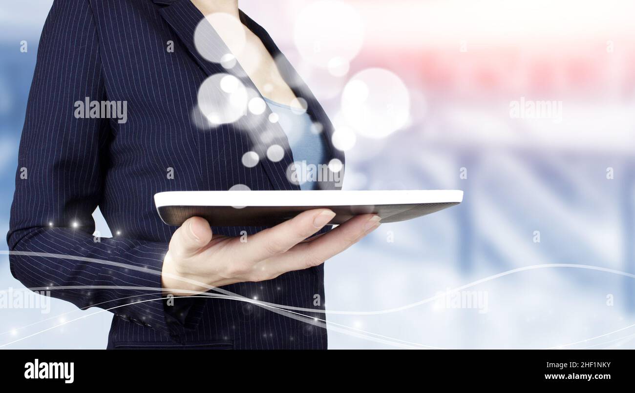 Concetto di tecnologia di innovazione e comunicazione delle reti aziendali. Tenere la compressa bianca con cerchi di ologramma digitale segno sulla luce sfocata. Automati Foto Stock