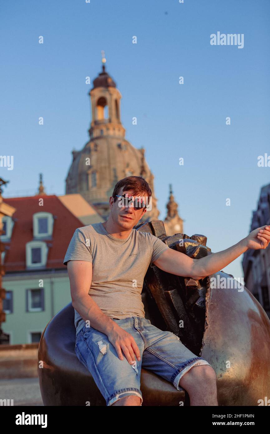 persona seduta su una scultura in una città Foto Stock