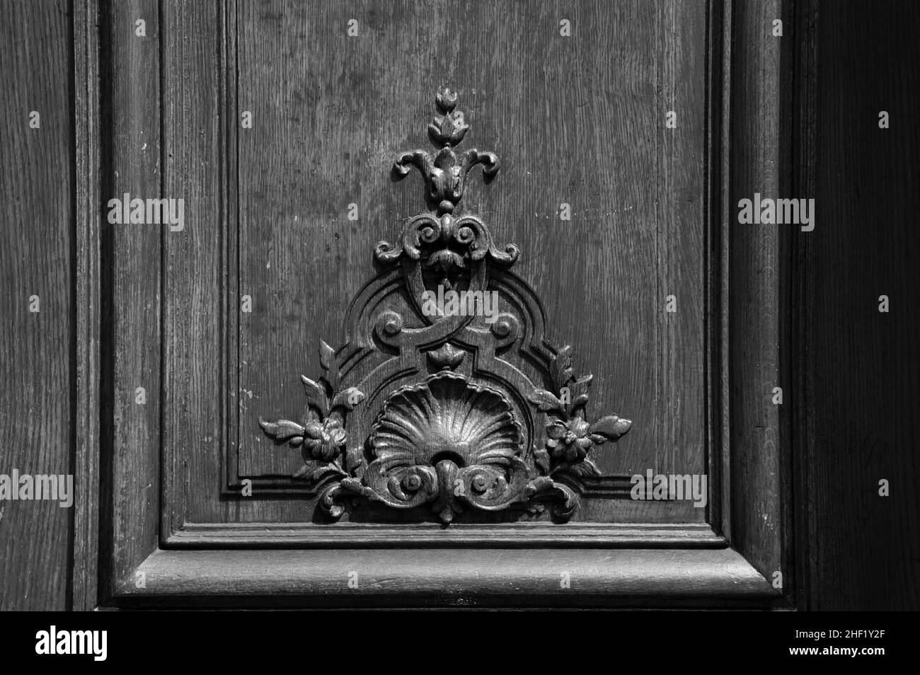 Vecchia porta in legno con intagliatura floreale. Parigi, Francia. Foto storica in bianco e nero Foto Stock