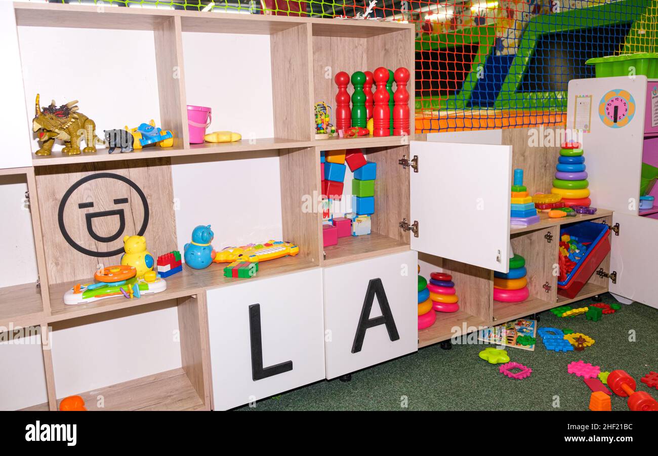 Armadietti con giocattoli nel centro di intrattenimento per bambini, giocattoli per bambini sul rack Foto Stock