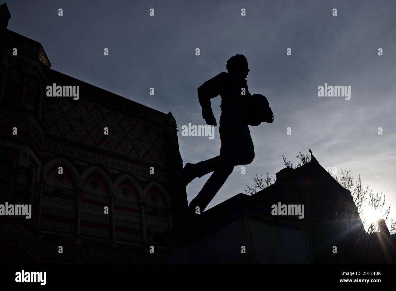 Scuola di Rugby, Rugby, Inghilterra. Statua di William Webb Ellis e la scuola di rugby sullo sfondo. Ellis presumibilmente 'inventò' il rugby nel 1823. Foto Stock