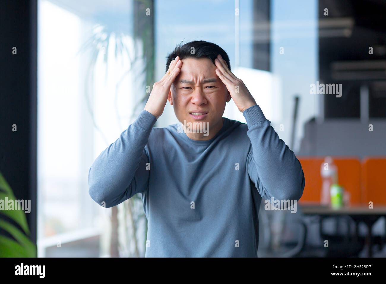 Ritratto di un dipendente serio e arrabbiato, guardando la fotocamera e gesturando con le mani, asiatico comunica su una videochiamata, guarda la webcam Foto Stock