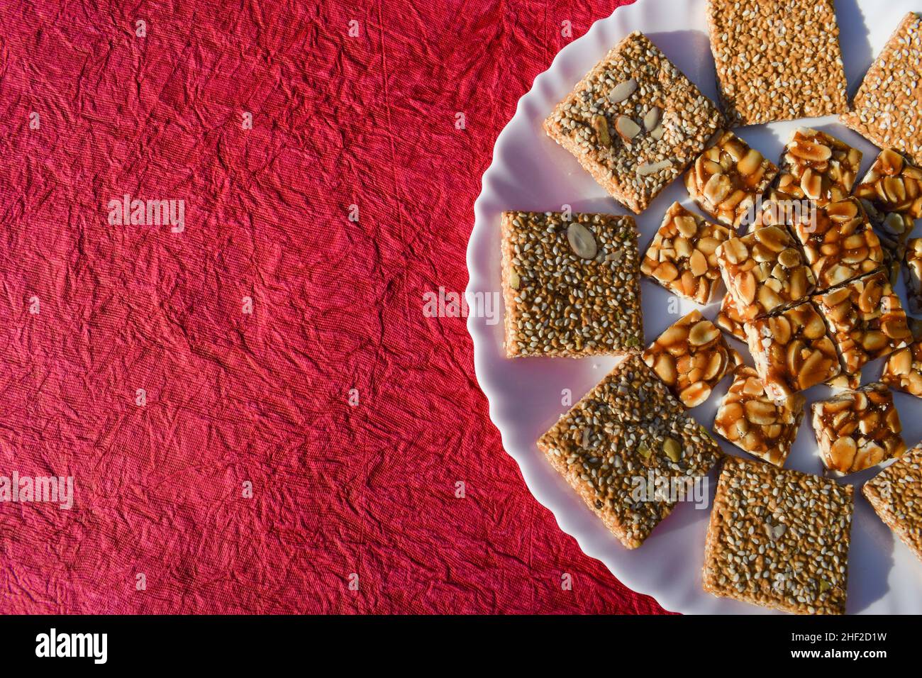 Gustose britles indiane di sesamo e barrette di caramelle di jaggery di Peanut conosciute come Til chikki e Peanut o shenga singhdana chikki decorati serviti durante Foto Stock